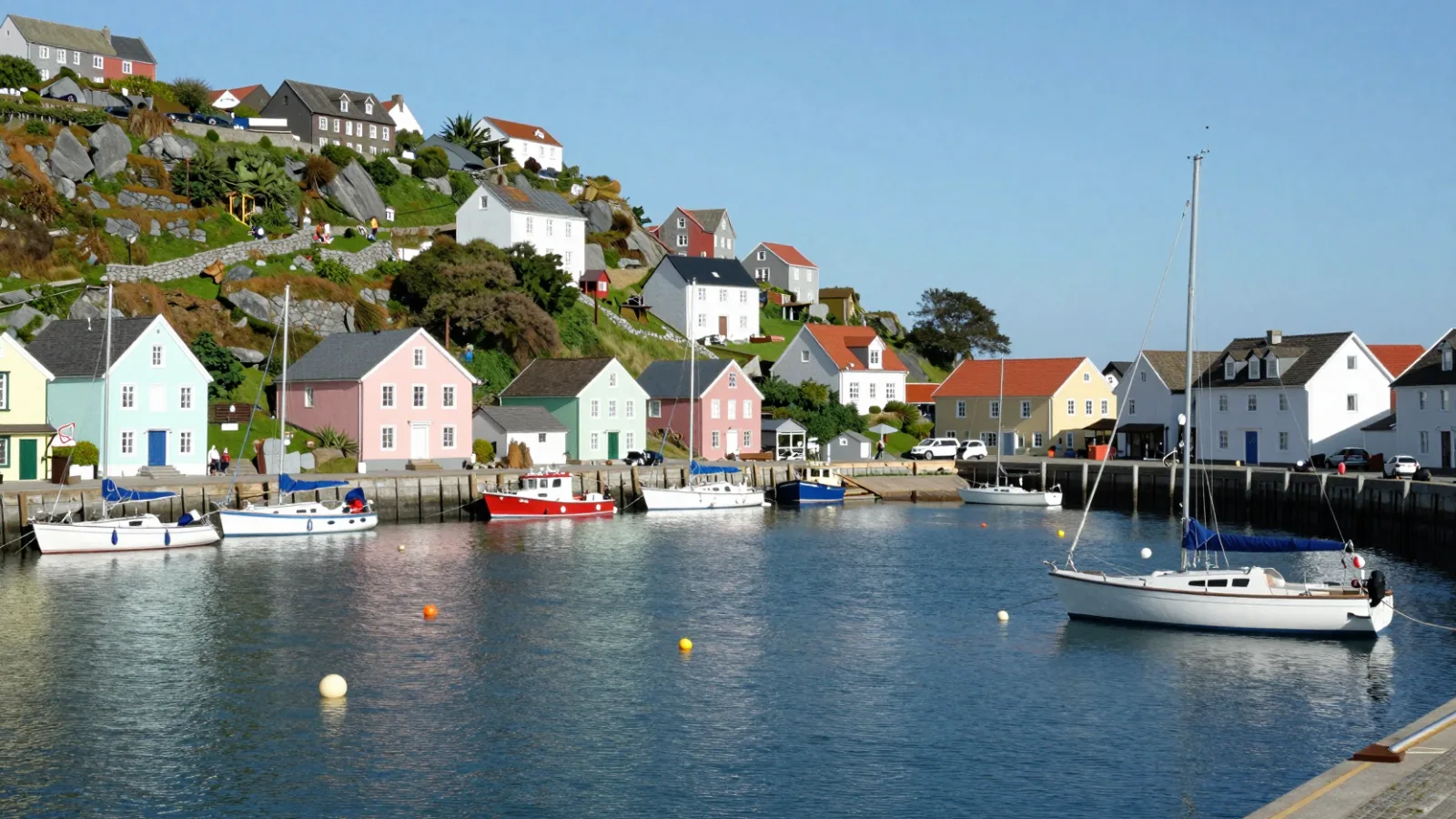 A colorful seaside town with boats in a small harbor on a sunny day