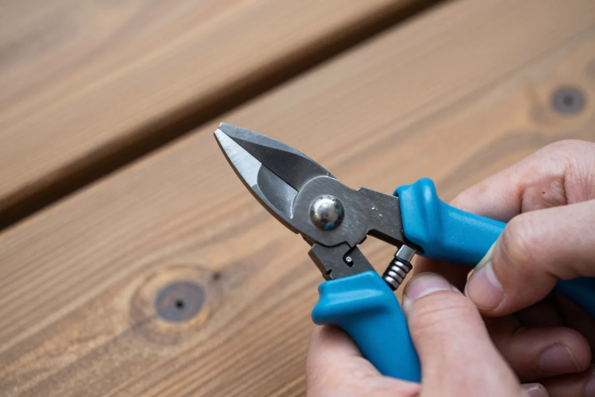Sharpening the beveled blade of bypass pruners with a diamond file